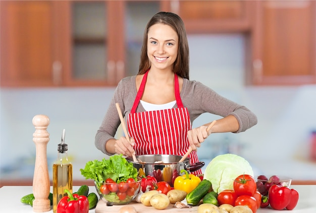 Mujer hermosa joven cocinando en la cocina