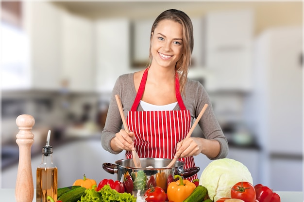 Mujer hermosa joven cocinando en la cocina