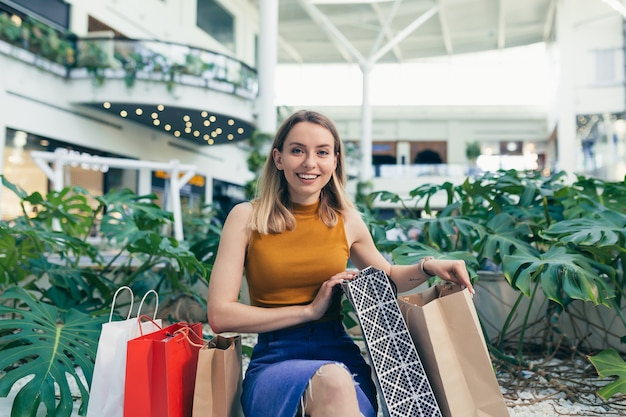 Mujer hermosa joven considera sus compras realizadas en el supermercado durante los descuentos