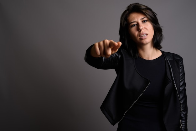 Mujer hermosa joven contra fondo gris