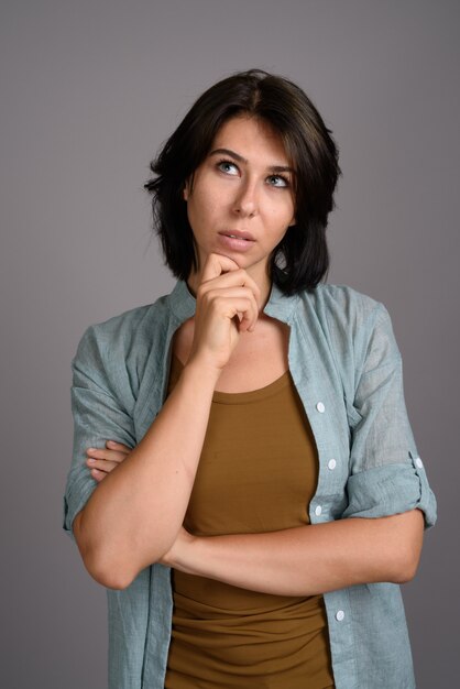 Foto mujer hermosa joven contra fondo gris