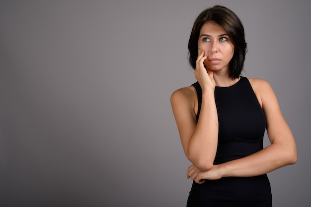 Mujer hermosa joven contra fondo gris