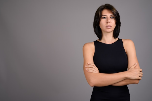 Mujer hermosa joven contra fondo gris