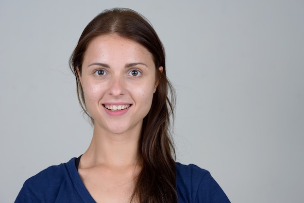 mujer hermosa joven contra la pared blanca