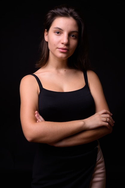 mujer hermosa joven contra la pared negra