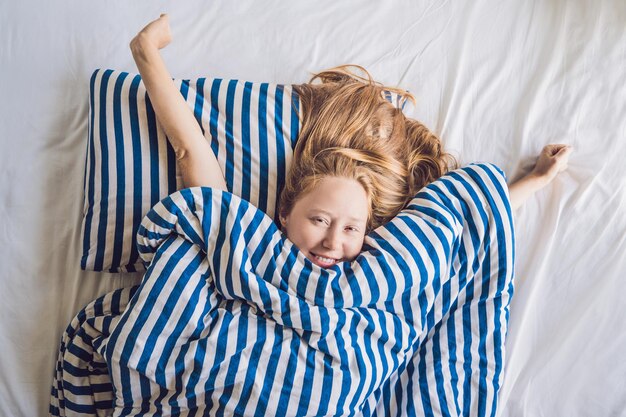 Foto mujer hermosa joven se despertó en primer plano de la cama