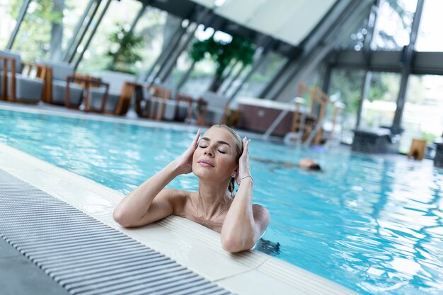 Foto mujer hermosa joven disfrutando en el jacuzzi mientras pasa un día de relax en el spa de salud.