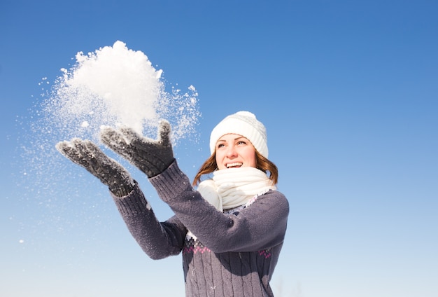 Mujer hermosa joven divirtiéndose en el brillante día de invierno