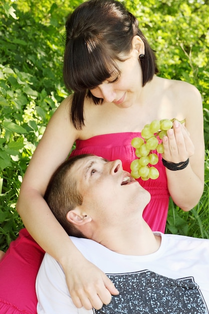 Mujer hermosa joven está amamantando a sus amadas uvas