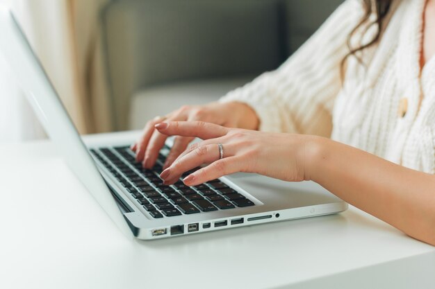 La mujer hermosa joven está comprando en línea. Trabajando en Internet. Oficina en casa. COVID-19.