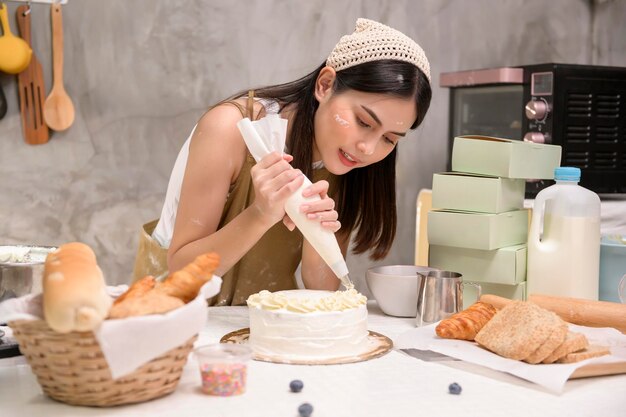 Mujer hermosa joven está horneando en su negocio de panadería y cafetería de cocina