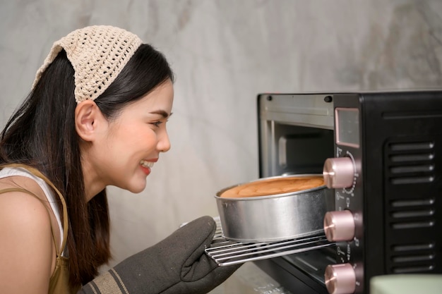Mujer hermosa joven está horneando en su negocio de panadería y cafetería de cocina