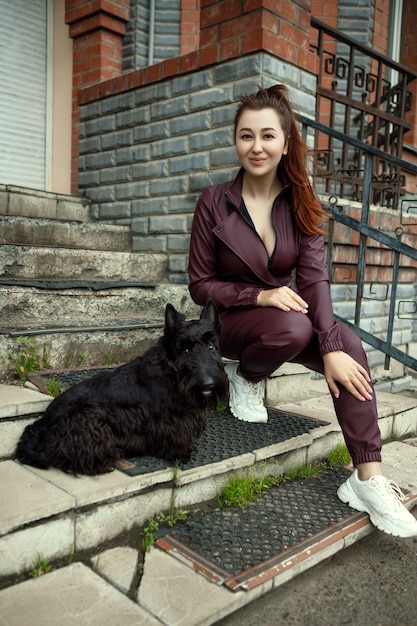 Mujer hermosa joven está posando en un mono de cuero casual en la ciudad