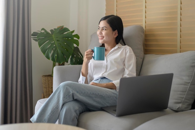 Mujer hermosa joven está trabajando con su computadora en casa