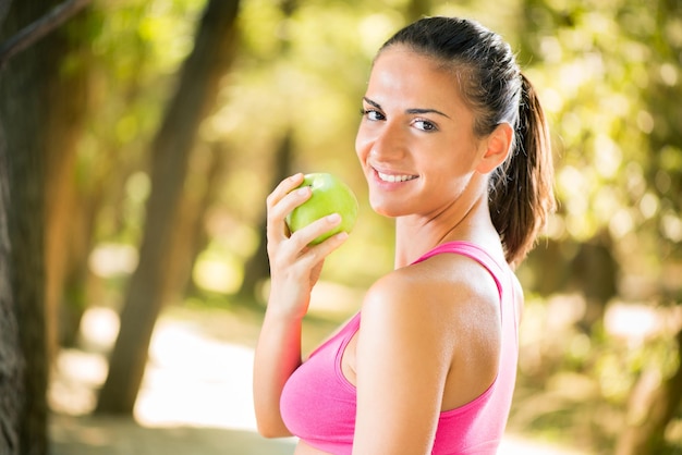 Foto mujer hermosa joven feliz con manzana en la naturaleza