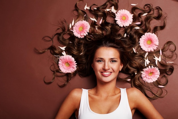 Mujer hermosa joven con flor rosa fresca