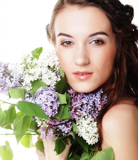 Mujer hermosa joven con flores lilas