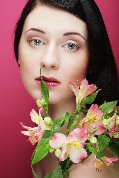 Mujer hermosa joven con flores rosas