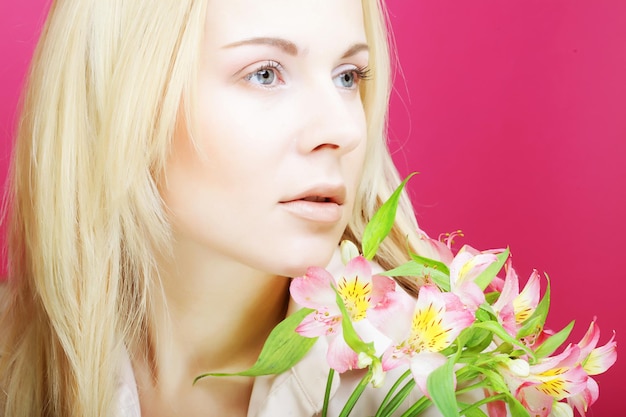 Mujer hermosa joven con flores rosas