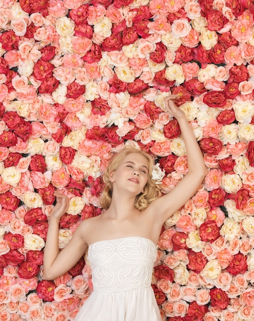 mujer hermosa y joven con fondo lleno de rosas