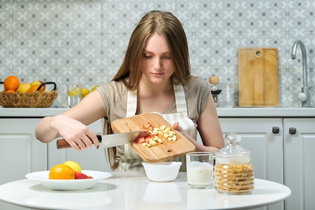 Mujer hermosa joven con frutas en la cocina