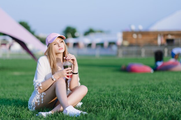 Mujer hermosa joven con una gorra en un festival de verano