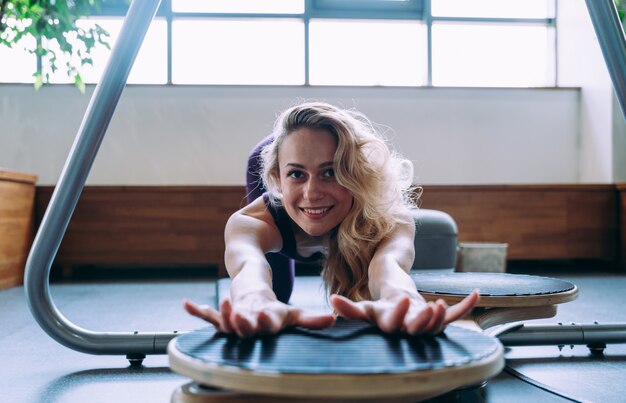 Mujer hermosa joven haciendo pilates y rehabilitación física en el gimnasio