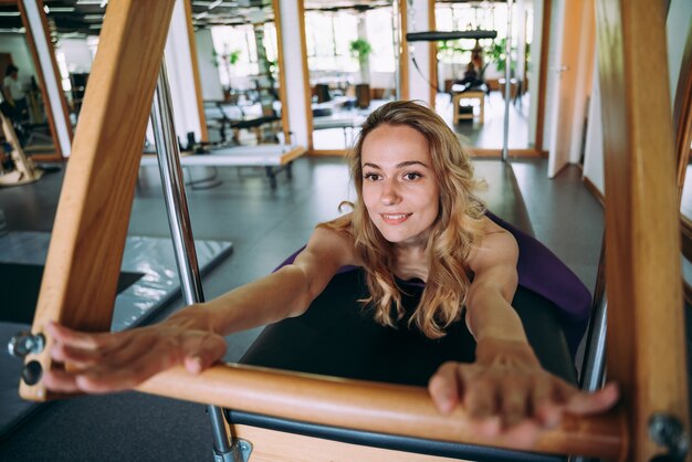 Mujer hermosa joven haciendo pilates y rehabilitación física en el gimnasio