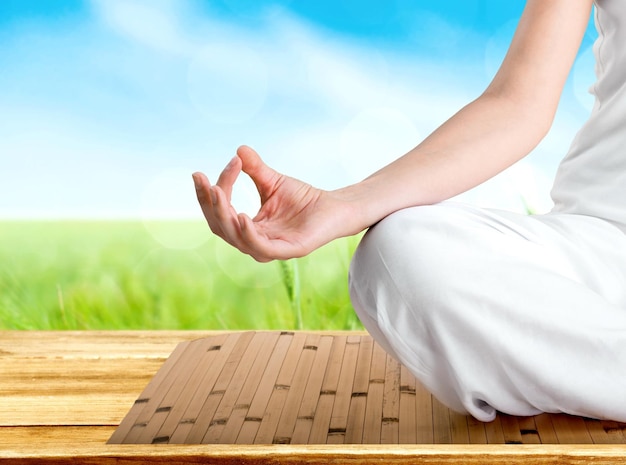 Mujer hermosa joven haciendo yoga en el fondo