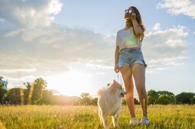 Mujer hermosa joven jugando con perro.