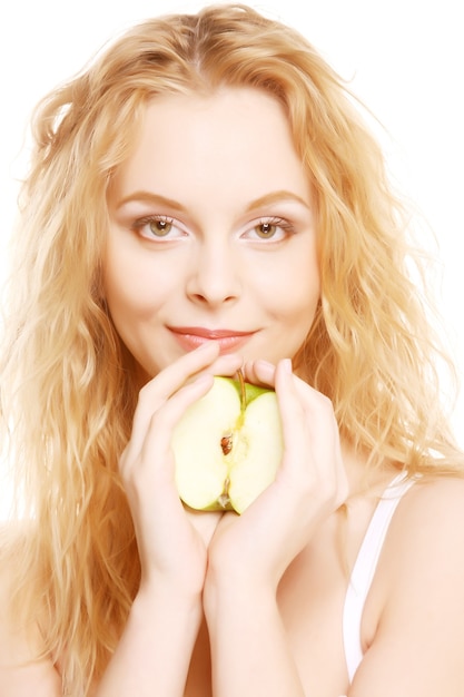 Mujer hermosa joven con una manzana mirando hacia la cámara