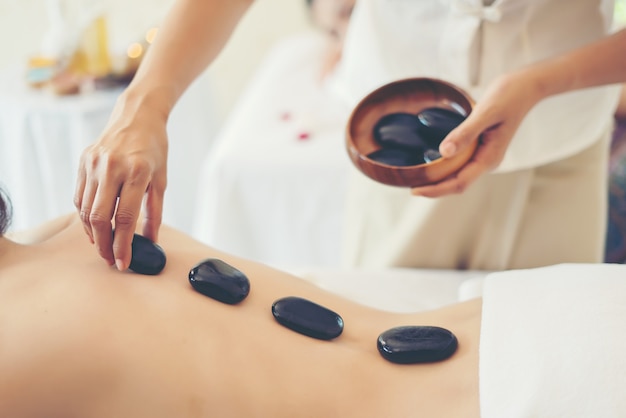 Mujer hermosa joven con masaje saludable de cuerpo en el salón de spa. Concepto de belleza