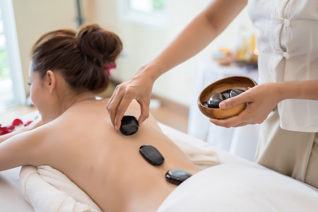 Mujer hermosa joven con masaje saludable de cuerpo en el salón de spa. Concepto de belleza