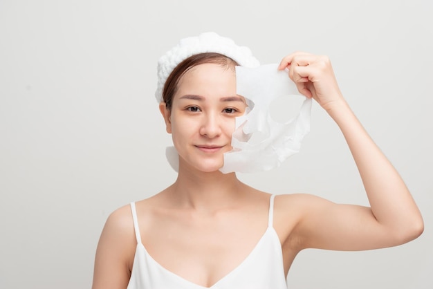 Mujer hermosa joven en una mascarilla para el cuidado de la piel