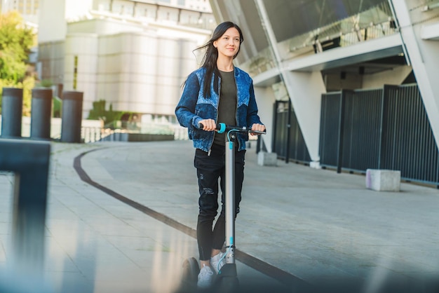 Mujer hermosa joven montando un scooter eléctrico por diversión