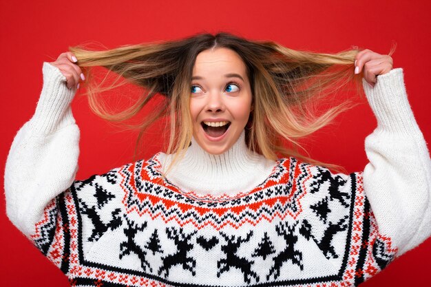 Mujer hermosa joven. Mujer de moda en suéter casual de invierno. La mujer positiva muestra emociones faciales.