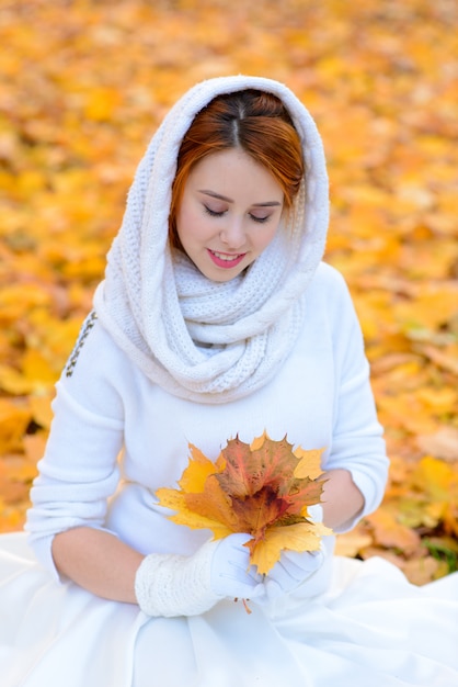 Mujer hermosa joven pelirroja en el parque otoño