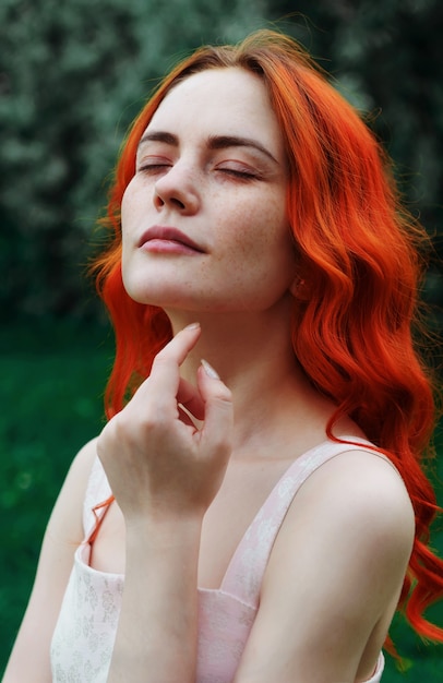 Mujer hermosa joven con pelo rojo y pecas sobre una superficie verde