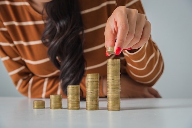 Foto mujer hermosa joven con pila de monedas