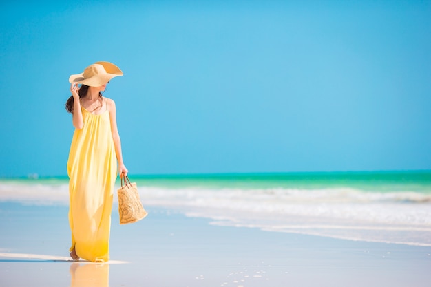 Mujer hermosa joven en la playa tropical de arena blanca