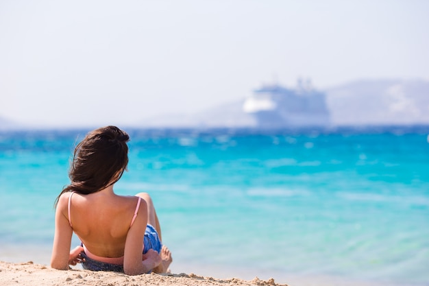 Mujer hermosa joven en la playa durante vacaciones tropicales. Chica disfruta su wekeend en una de las hermosas playas de Mykonos, Grecia, Europa.