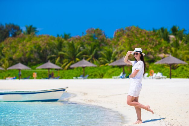 Mujer hermosa joven en la playa durante vacaciones tropicales