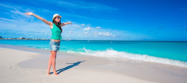 Mujer hermosa joven en la playa durante vacaciones tropicales