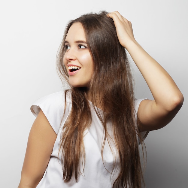 Mujer hermosa joven posando con camisetas blancas, fondo blanco ower