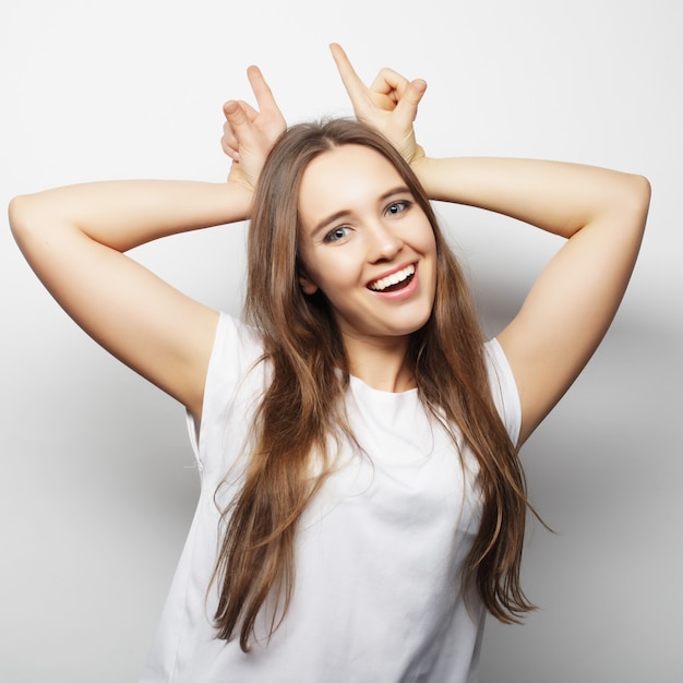 Mujer hermosa joven posando con camisetas blancas, fondo blanco ower