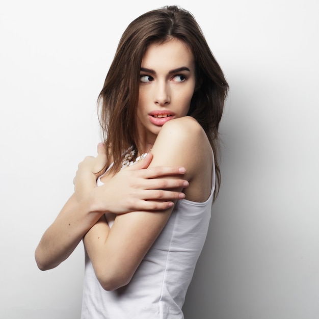 Mujer hermosa joven posando con camisetas blancas, fondo blanco ower