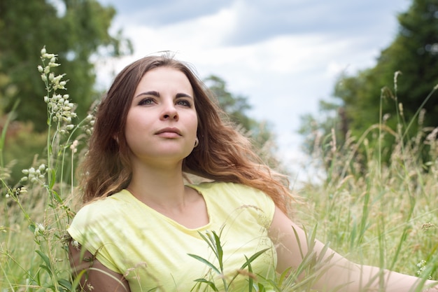 Mujer hermosa joven en un prado en la hierba