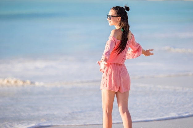 Mujer hermosa joven que se divierte en la costa tropical.