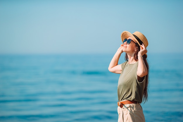 Mujer hermosa joven que se divierte en la orilla del mar tropical.