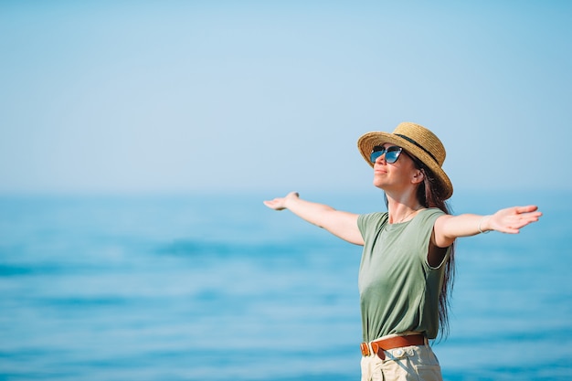 Mujer hermosa joven que se divierte en la orilla del mar tropical.